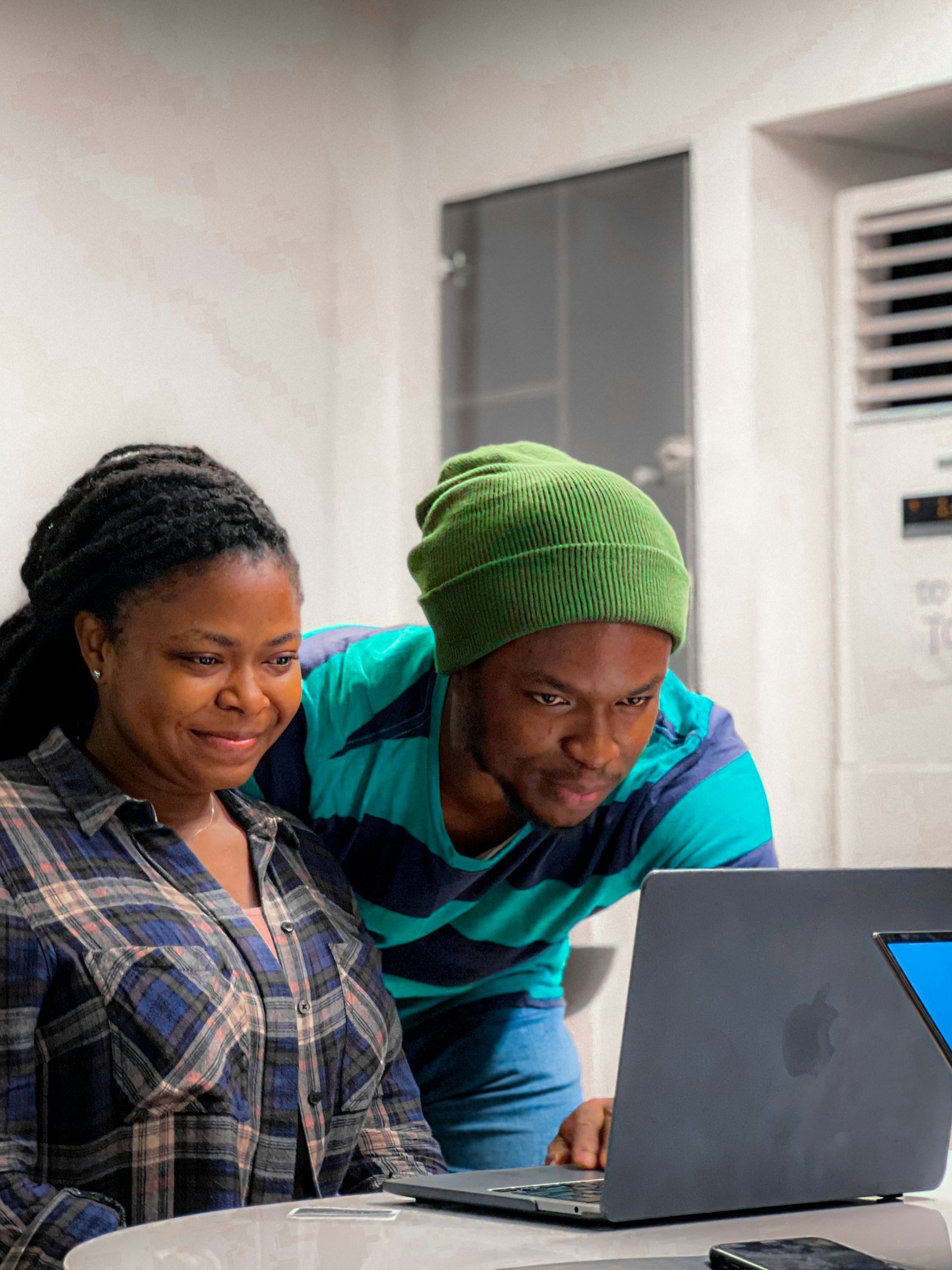 Two colleagues smiling while working at a laptop